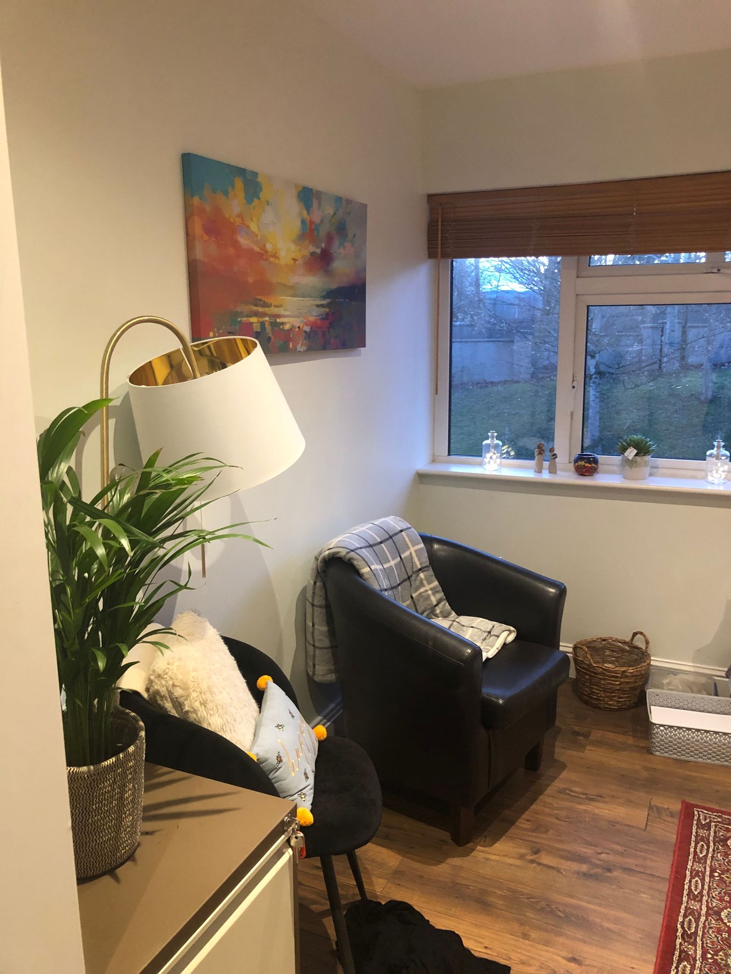 Comfortable therapy seating area with colorful artwork and natural window light